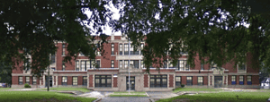 Vintage Gothic Revival school building in Memphis with historic architecture, surrounded by mature trees, highlighting Memphis Heritage Inc.'s preservation of local historic landmarks.