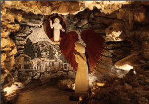 A religious angel statue with red wings inside a cave, featuring historic murals and a haloed figure at the back, representing Memphis Heritage Inc.'s cultural and historic preservation efforts.