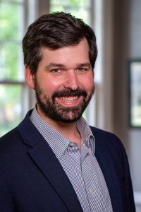 Professional portrait of a smiling man in business attire, representing Memphis Heritage Inc., showcasing community leadership, historical preservation, and Memphis local culture.