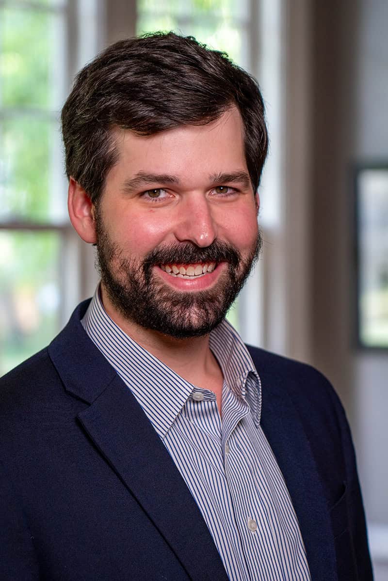 Professional portrait of a smiling man in business attire, representing Memphis Heritage Inc., showcasing community leadership, historical preservation, and Memphis local culture.